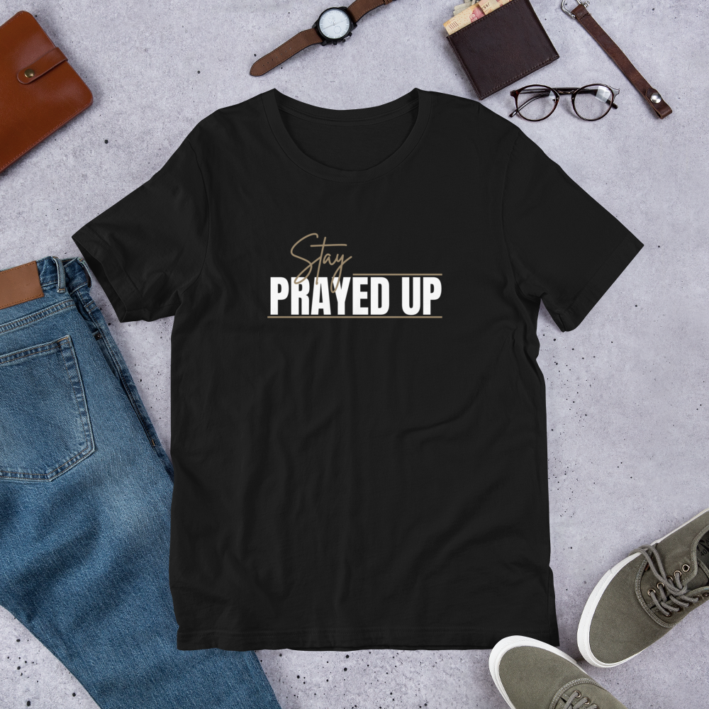 Black Stay Prayed Up Tee flatlay with bold white and gold faith-based design